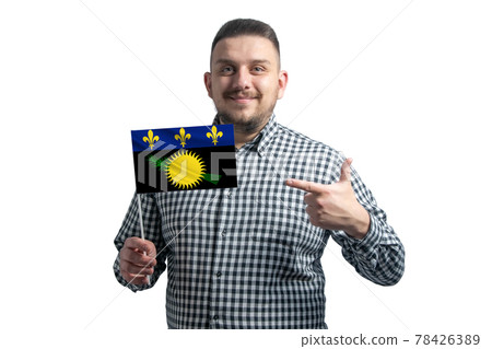 White guy holding a flag of Guadeloupe and points the finger of the other hand at the flag isolated on a white background White guy holding a flag of Guadeloupe and points the finger of the other hand at the flag isolated on a white background 78426389