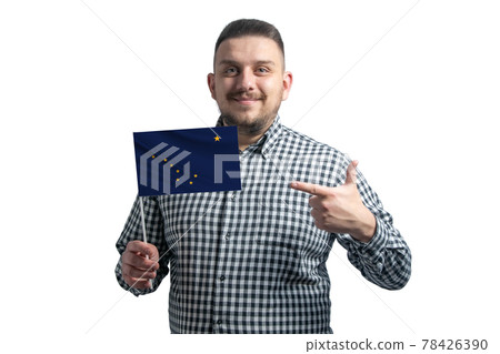White guy holding a flag of Alaska and points the finger of the other hand at the flag isolated on a white background 78426390