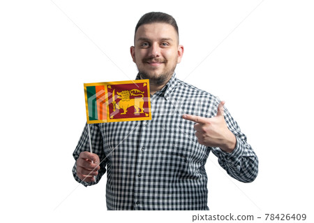 White guy holding a flag of Sri Lanka and points the finger of the other hand at the flag isolated on a white background 78426409
