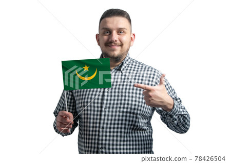 White guy holding a flag of Mauritania and points the finger of the other hand at the flag isolated on a white background 78426504
