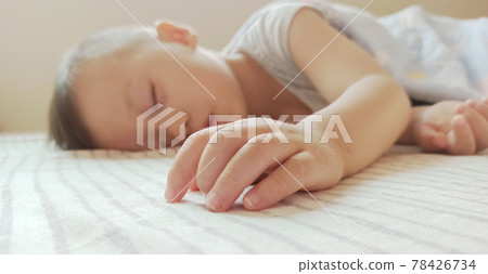 Boy sleeping on the side of the bed 78426734