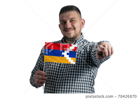 White guy holding a flag of Nagorno-Karabakh Republic and points forward in front of him isolated on a white background White guy holding a flag of Nagorno-Karabakh Republic and points forward in front of him isolated on a white background 78426870