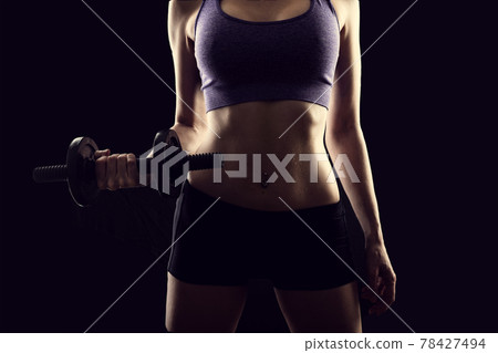 Slim athletic woman Holding dumbbell in the hand Slim athletic woman Holding dumbbell in the hand 78427494