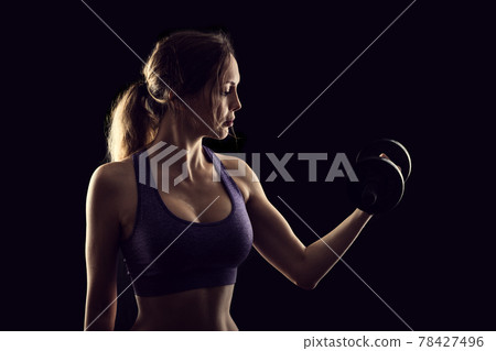 Slim athletic woman Holding dumbbell in the hand Slim athletic woman Holding dumbbell in the hand 78427496