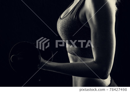 Slim athletic woman Holding dumbbell in the hand Slim athletic woman Holding dumbbell in the hand 78427498