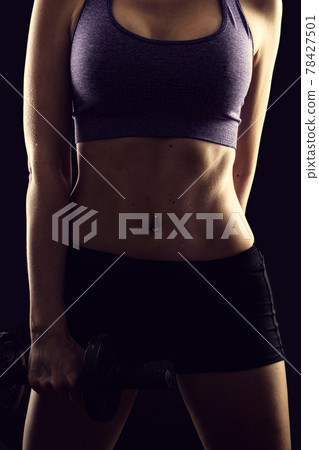 Slim athletic woman Holding dumbbell in the hand Slim athletic woman Holding dumbbell in the hand 78427501