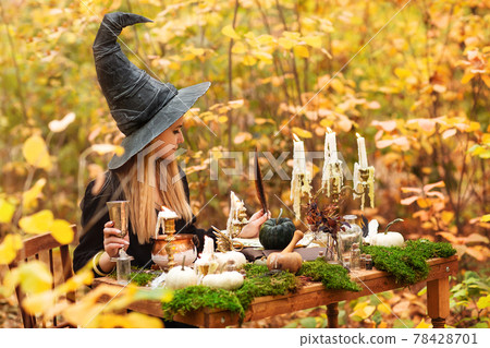 Young witch writing spells in forest Young witch writing spells in forest 78428701