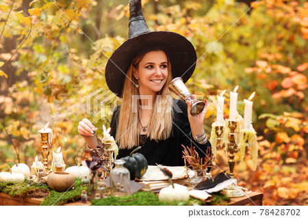 Young witch writing spells in forest Young witch writing spells in forest 78428702