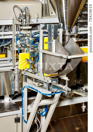 Detail of a production line in the food industry for packaging bulk products in yellow paper bags. 78429619