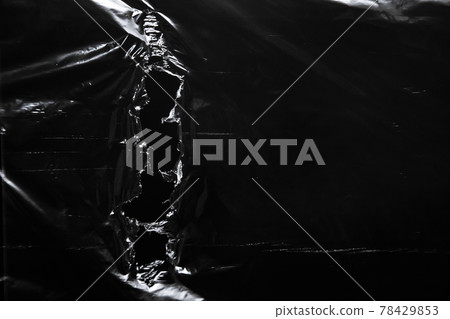 Polyethylene surface with ragged hole on black background Polyethylene surface with ragged hole on black background 78429853