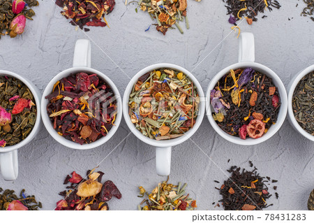 Set of white cups with assortment of dry tea. 78431283