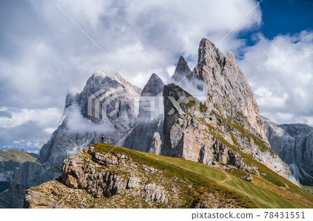 A man in front of epic Furchetta and Sass Rigais peaks in Seceda, Dolomites Alps, Odle mountain range, South Tyrol, Italy, Europe. Travel vacation concept A man in front of epic Furchetta and Sass Rigais peaks in Seceda, Dolomites Alps, Odle mountain range, South Tyrol, Italy, Europe. Travel vacation concept 78431551