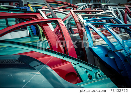 different colored car doors at a car junkyard 78432755