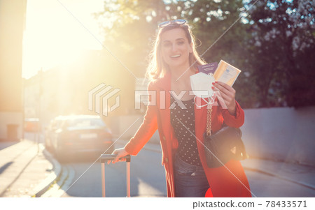 Woman with vaccination passport and mask ready to travel 78433571