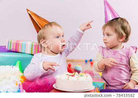 Two toddlers with birthday cake 78433582