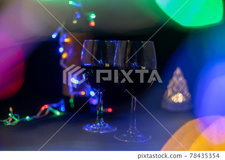 two wine glasses in a shining garland bokeh on a black background... two wine glasses in a shining garland bokeh on a black background... 78435354