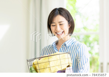 A smiling woman with a laundry basket A smiling woman with a laundry basket 78435857
