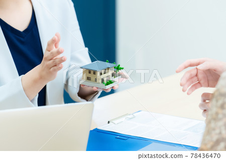 Female house maker designer explaining with a house model 78436470