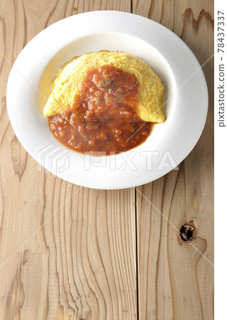Take a bird's-eye view of a hot omelet rice or omelet with meat sauce on a wooden board 78437337