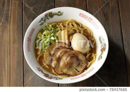 A bird's-eye view of pork bone soy sauce ramen containing roasted char siu, taste balls, menma and all-purpose green onions 78437680