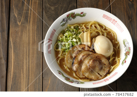 A bird's-eye view of pork bone soy sauce ramen containing roasted char siu, taste balls, menma and all-purpose green onions 78437682