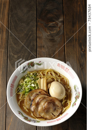 A bird's-eye view of pork bone soy sauce ramen containing roasted char siu, taste balls, menma and all-purpose green onions 78437684