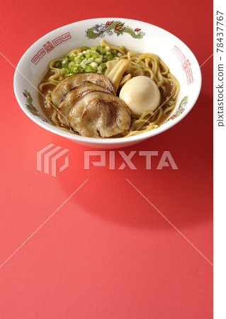 Photographed pork bone soy sauce ramen with roasted char siu, taste balls, menma and all-purpose green onions on a red background 78437767