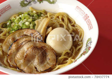 Photographed pork bone soy sauce ramen with roasted char siu, taste balls, menma and all-purpose green onions on a red background 78437774