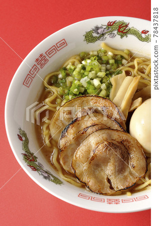 A bird's-eye view of pork bone soy sauce ramen containing roasted char siu, taste balls, menma and all-purpose green onions on a red background A bird's-eye view of pork bone soy sauce ramen containing roasted char siu, taste balls, menma and all-purpose green onions on a red background 78437818