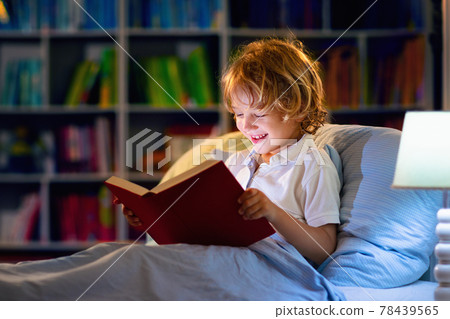 Child reading book in bed. Kids read at night. Child reading book in bed. Kids read at night. 78439565