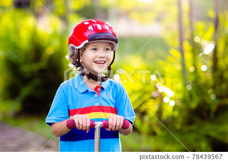 Little boy riding scooter. Kids ride kick board. 78439567
