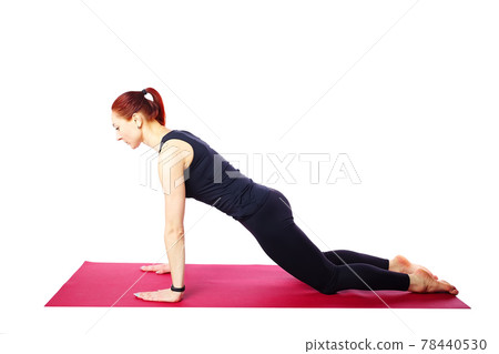 A slender athletic girl does push-ups from her knees on a gym mat.Exercises for the development of 78440530