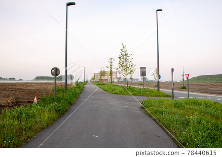 Street in the landscape and in the end a big building 78440615