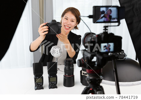 A woman shooting a video with an SLR camera A woman shooting a video with an SLR camera 78441719