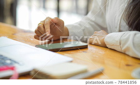 Cropped shot of female office worker working with smartphone on the desk Cropped shot of female office worker working with smartphone on the desk 78441856