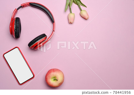 Mock up mobile phone, headphone, apple and pink tulips on pink background. Mock up mobile phone, headphone, apple and pink tulips on pink background. 78441956