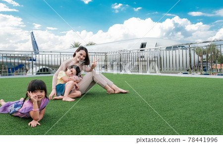 happy family baby kids and mother woman sitting fun in front of the plane happy family baby kids and mother woman sitting fun in front of the plane 78441996