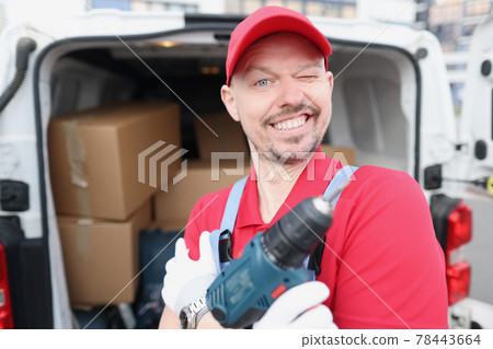 Master repairman holding electric drill in his hands near car Master repairman holding electric drill in his hands near car 78443664