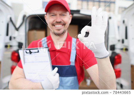 Man courier holding documents and showing okay gesture near car with boxes 78443665
