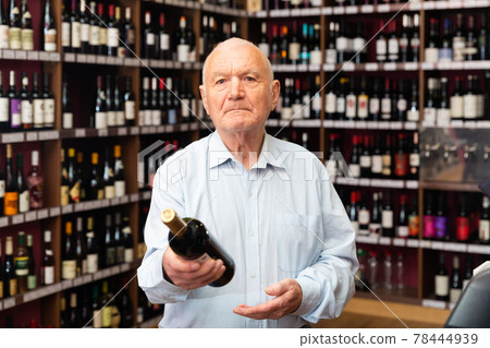 Portrait of senior man visiting winehouse in search of bottle of good wine 78444939