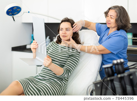 Cosmetologist explains to the patient the procedure of cosmetological operation Cosmetologist explains to the patient the procedure of cosmetological operation 78445396