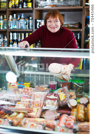 seller woman offering sausage products seller woman offering sausage products 78445466