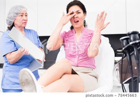 Portrait of an outraged young female patient in a clinic after procedures Portrait of an outraged young female patient in a clinic after procedures 78445663