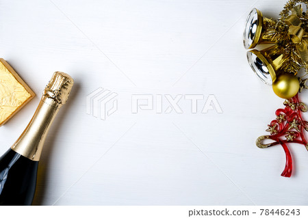 New Year's decorations, present, champagne on white wooden background with copy space. New Year's decorations, present, champagne on white wooden background with copy space. 78446243