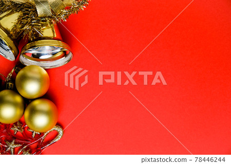 New Year's decorations, tinsel and bells on red background with copy space. New Year's decorations, tinsel and bells on red background with copy space. 78446244
