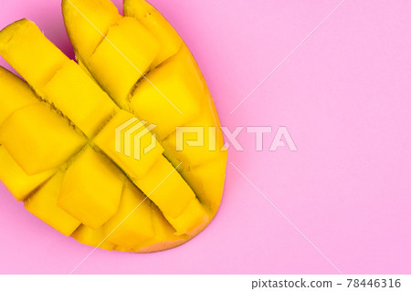 Fresh ripe mango on a pink background. Half a sliced mango on a pink background Fresh ripe mango on a pink background. Half a sliced mango on a pink background 78446316