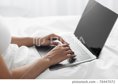 Remote work from home. African american lady typing on laptop with empty screen in bed, close up, free space Remote work from home. African american lady typing on laptop with empty screen in bed, close up, free space 78447072