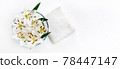 Transparent vase with water and white lilies with a white towel. Isolated on white. Spa concept for cleanliness, freshness and aromatherapy. 78447147