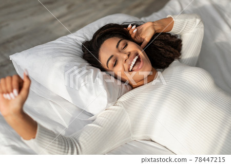 Happy African American lady stretching after waking up 78447215