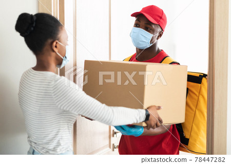 African American Courier Wearing Mask Delivering Box To Customer's Home African American Courier Wearing Mask Delivering Box To Customer's Home 78447282